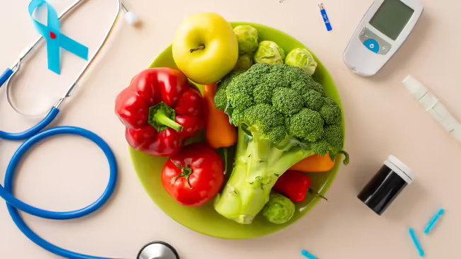 Bowl of fresh vegetables with a glucose meter, insulin supplies, and a stethoscope, representing healthy eating and diabetes care.