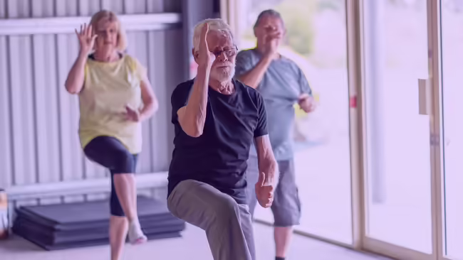 Three older people performing tai chi movements. 
