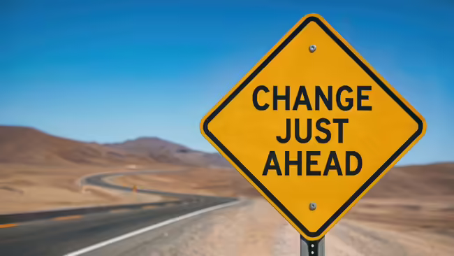 A yellow road sign that reads "change just ahead."