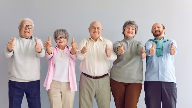 Men and Women standing in a line giving a thumbs up