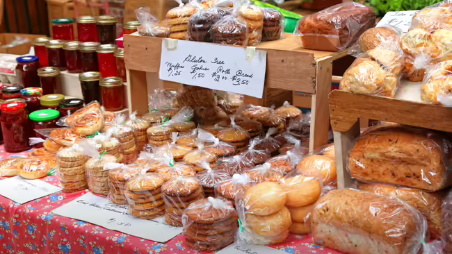 Baked goods and jams displayed on a table to be sold.