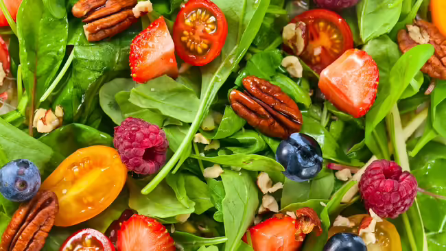 Salad closeup with berries and nuts.