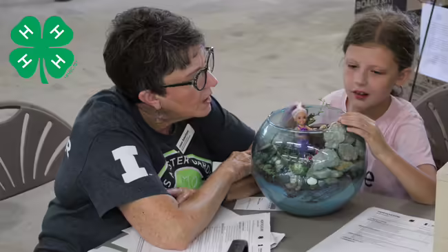 Woman and youth presenting a project with a green clover on the left hand corner
