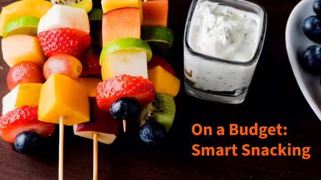 Different kinds of fruit on a skewer with cup of yogurt