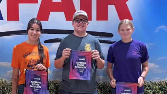 three youth holding champion banners