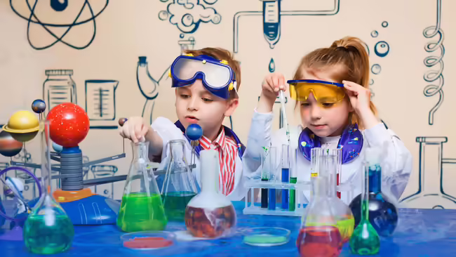a young boy and girl dressed as scientists near scientific equipment
