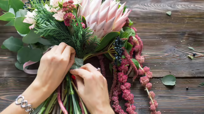 hands tying ribbon on bouquet of flowers