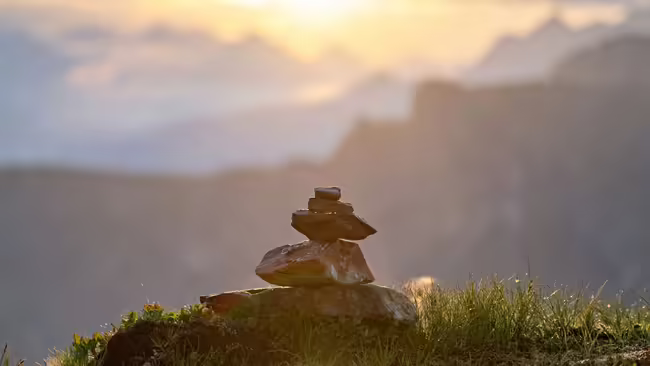 Rocks stacked with view of mountains and sky in the background