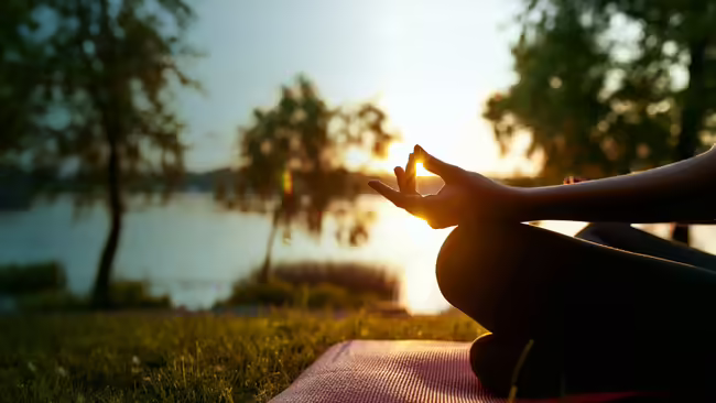 person doing yoga by pond