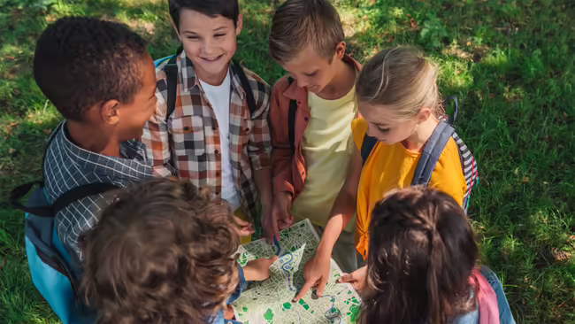 kids standing in circle looking at map
