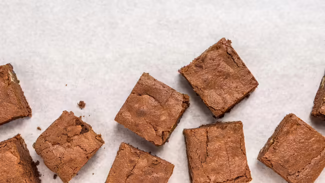 Several brownies on a table. 