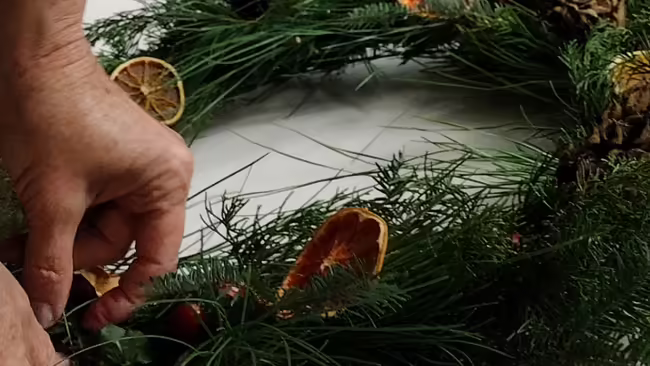 person making wreath from natural materials