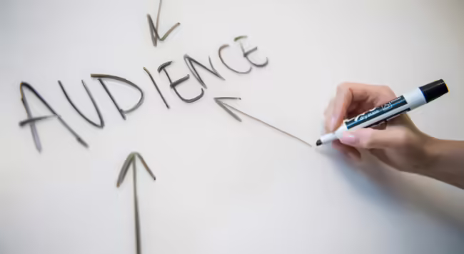 hand with marker drawing arrows pointing toward word "audience"