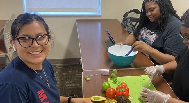 Teens sitting at table with cooking utensils