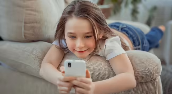 Young girl playing on a smartphone.
