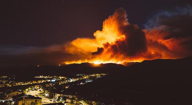 a fire burns at night in California just outside a city