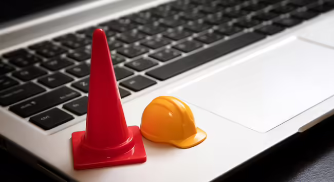 Traffic cone and hardhat on a laptop keyboard