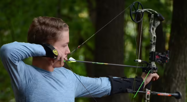 Boy shooting a bow & arrow