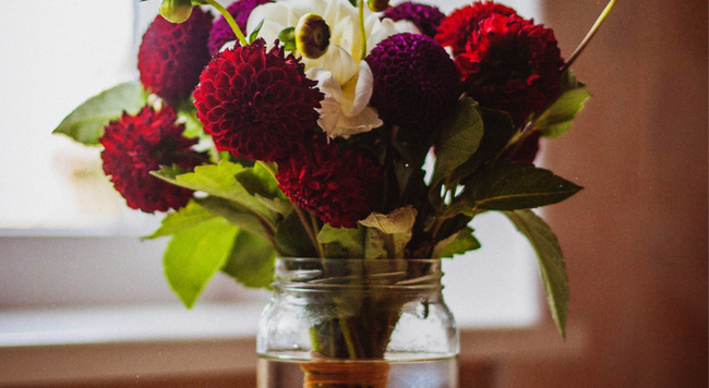 assorted cut flowers in a wide mouth jar. credit: 