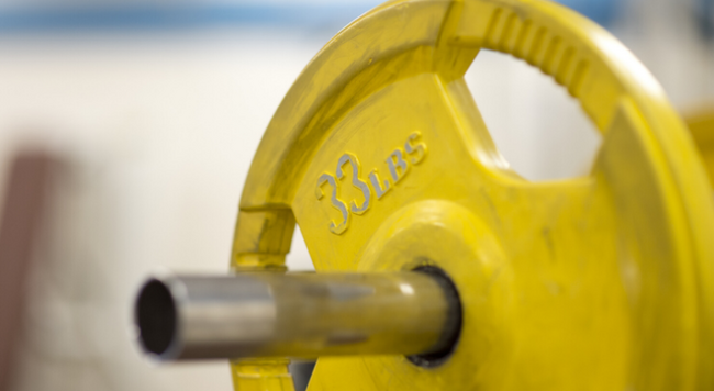 Yellow weight on a barbell.