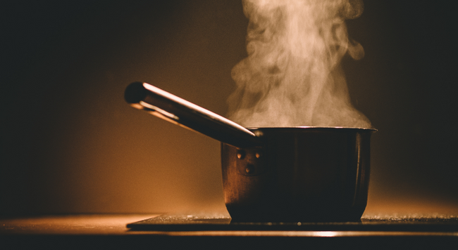 A pot on a stove with steam coming off the top