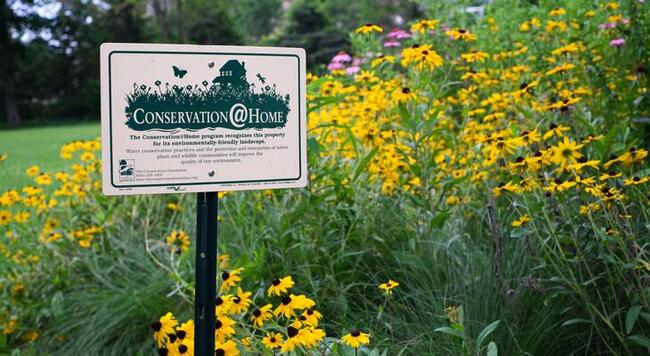 Conservation at Home sign in a flower garden