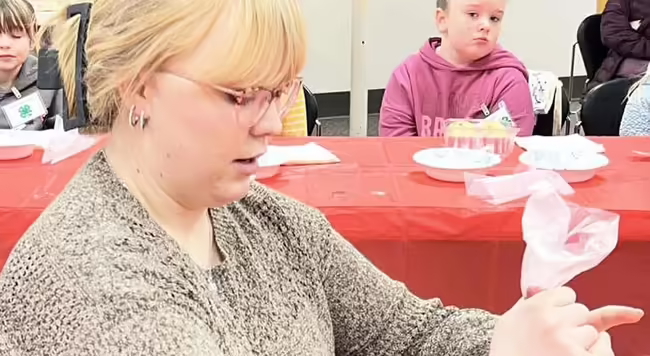Young woman piping frosting on a cupcake