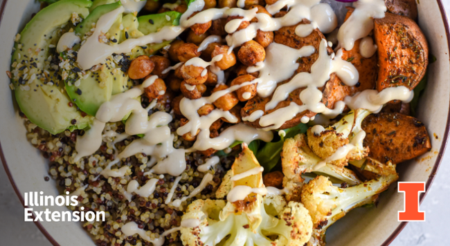 A grain bowl containing quinoa, roasted cauliflower, sweet potatoes, chickpeas, avocado slices, and a creamy white dressing. Contains Illinois Extension wordmark and orange I block logo. 