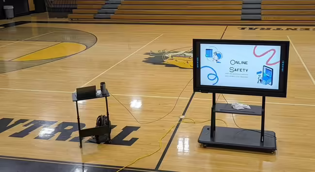 Picture of a presentation screen on a school gymnasium floor