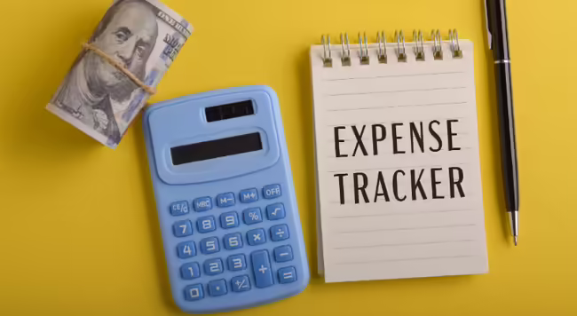 blue calculator and a notebook that says Expense Tracker