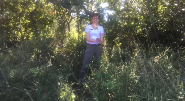 woman outside holding a grass