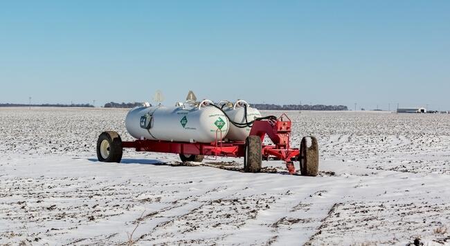 Anhydrous ammonia tanks in snowy farm field