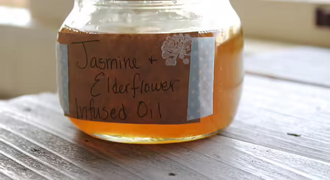 jasmine and elderflower infused oil in a mason jar on a counter
