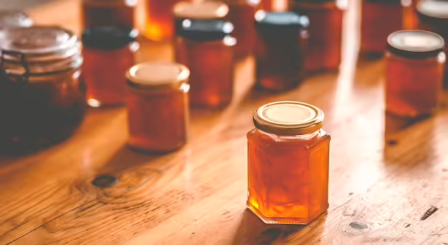 Image of jars of jam or jelly spread out on a tabletop 
