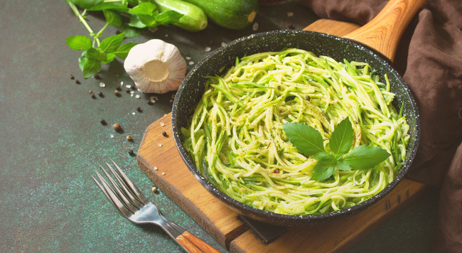 Plate of Zucchini noodles in a pan on a cutting board 