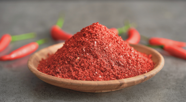 Pile of ground cayenne pepper on a wooden dish