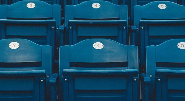 Two rows of seats in a sports stadium.
