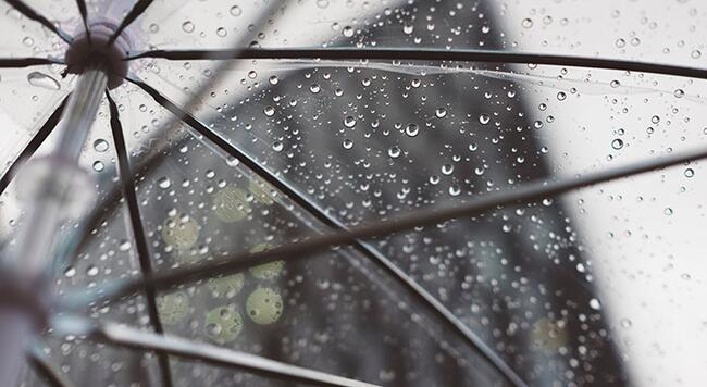 Raindrops hitting top of clear umbrella