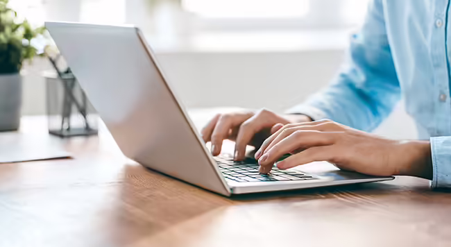 hands typing on a laptop