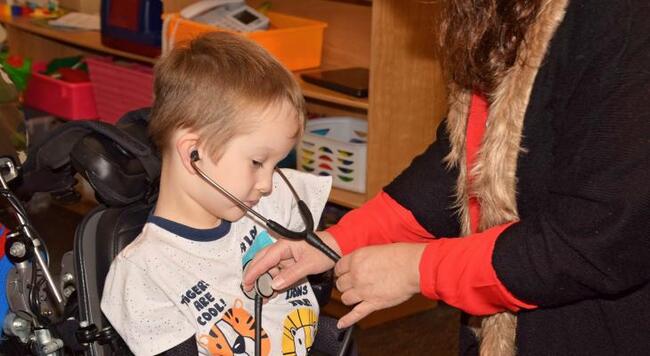 little boy in wheelchair using stethoscope