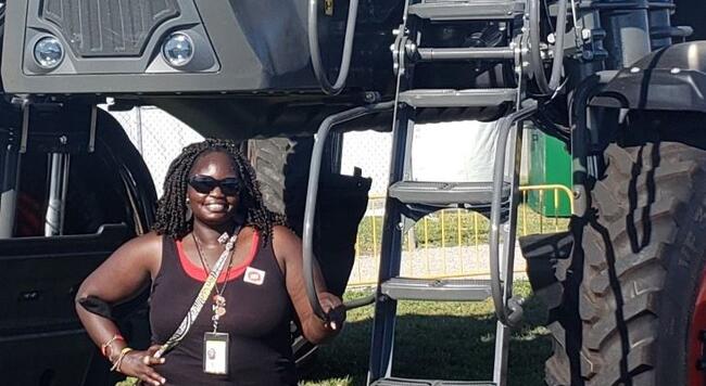 ISP Scholar Susan Ogwal in front of tractor at farm progress show