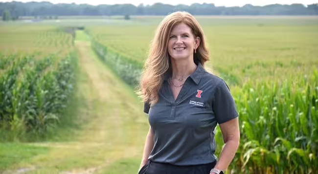 Woman standing with a cornfield in the background