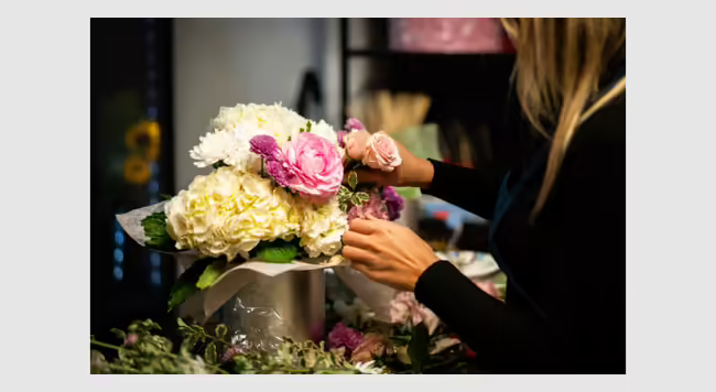 woman arranging floral bouquet