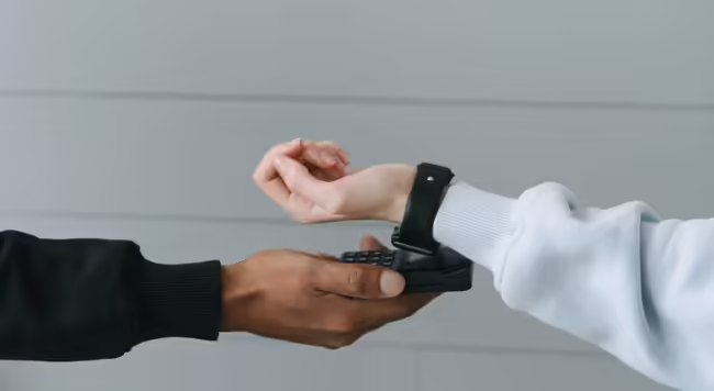 person holding phone while another person holds watch face to phone
