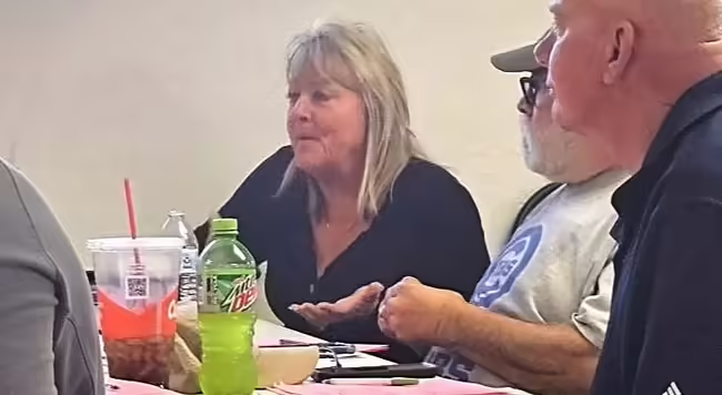 People sitting at a table with one person speaking