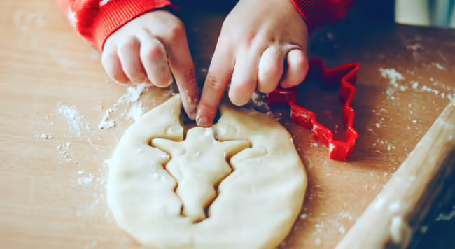 child making a christmas tree shaped cookie