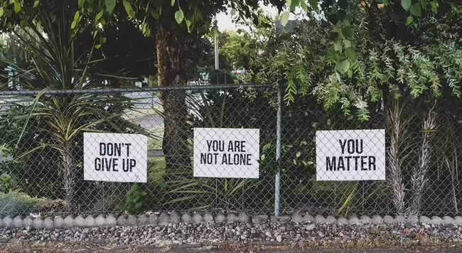 Fence with signs on it that say Don't give up and You Matter.