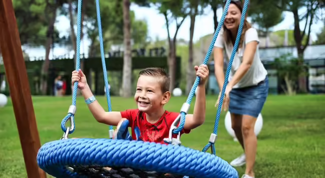child being pushed on swing
