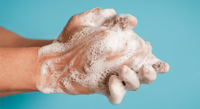 person rubbing soapy hands together