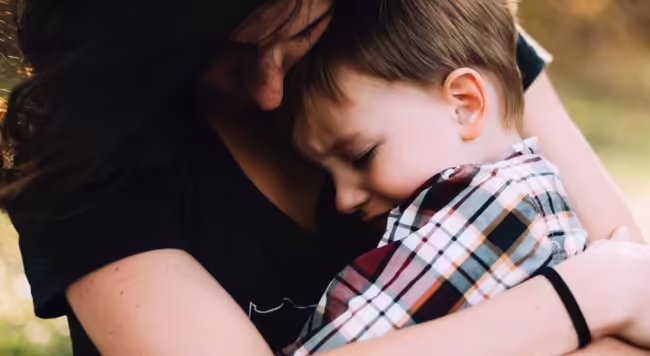 Upset child being soothed by adult
